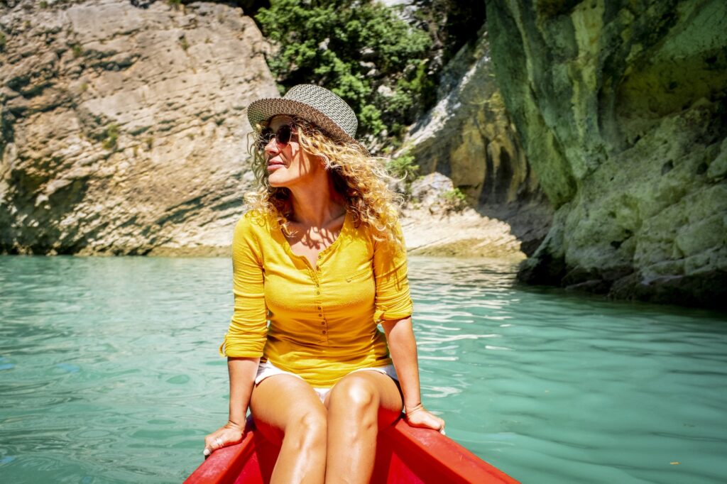 Cute adult tourist woman enjoy outdoor leisure activity sith kayak experience tour on a blue river